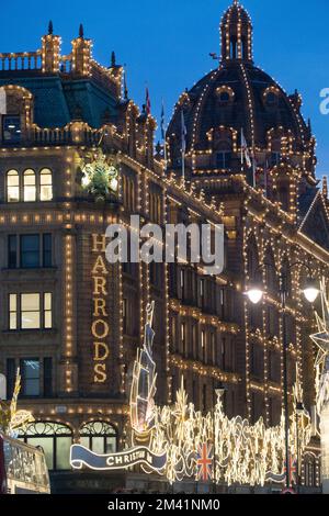 Londres, Royaume-Uni, 17 décembre 2022 : malgré la grève des chemins de fer, de nombreuses personnes étaient dehors à Londres pour voir les lumières de Noël pendant qu'ils faisaient leurs achats. Tandis que le soleil couchait les lumières à thème Christian Dior sur le grand magasin Harrods se démarquaient du ciel crépuscule. Anna Watson/Alay Live News Banque D'Images