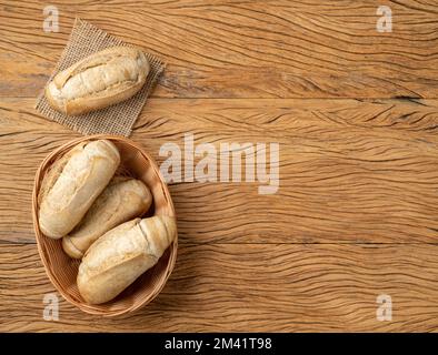 Pain français à grains entiers, pain salé ou pistolet dans un panier sur table en bois avec espace de copie. Banque D'Images