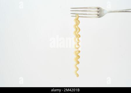 pâtes italiennes suspendues à une fourchette d'argent, isolées sur fond blanc, espace de copie gratuit Banque D'Images