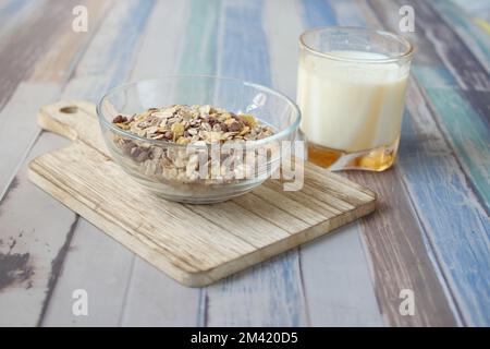 Granola musli dans un bol, et un verre de lait sur la table Banque D'Images