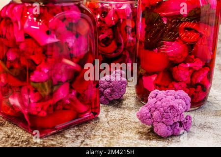 Cornichon maison au chou-fleur violet en pots sur fond gris Banque D'Images