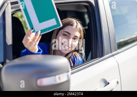 Bonne jeune femme pilote montrant son L signe lerner espagne autoescuela Banque D'Images