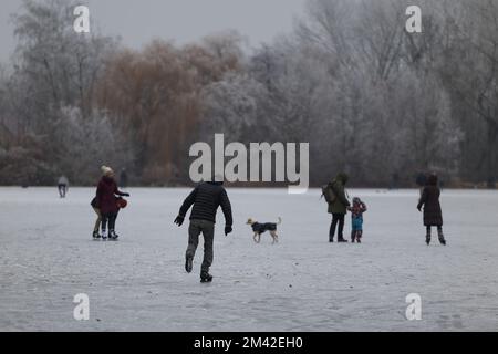 Berlin, Allemagne. 18th décembre 2022. Certaines personnes sont avec et sans patins sur l'étang de carpe gelé dans le district de Pankow. Le pergélisol des derniers jours a provoqué le gel de nombreux plans d'eau à Berlin et à Brandebourg et a attiré des gens sur la glace pendant le week-end. Credit: Jörg Carstensen/dpa/Alay Live News Banque D'Images