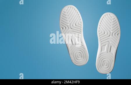 Deux semelles de chaussures de sport. Blanc. Façade sur fond bleu. Bannière Banque D'Images