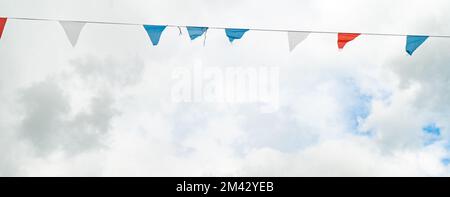 Une sélection de décorations de bunting contre le ciel bleu avec des nuages blancs Banque D'Images