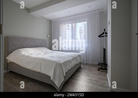 Intérieur d'une chambre blanche et lumineuse avec lit double Banque D'Images