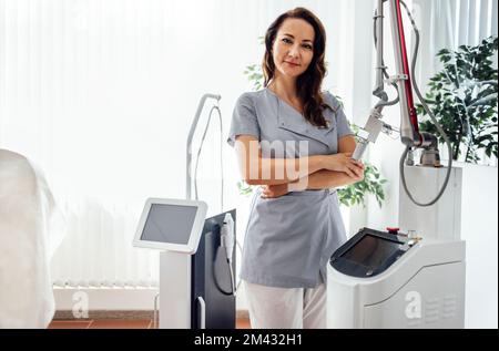 Portrait d'une esthéticienne féminine utilisant un masseur en salon. Cosmetologiste dans un salon de beauté. Dermatologue dans une clinique de beauté. Traitement du visage Banque D'Images