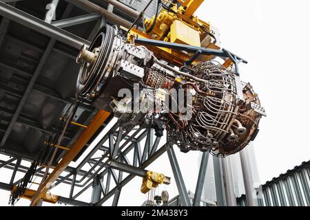 Le moteur d'un compresseur à turbine à gaz est suspendu à une grue lors de l'installation dans un module de production d'électricité Banque D'Images