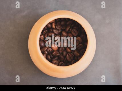 Grains de café dans un bol en argile. Café torréfié brun. Boisson à base de caféine. Café-restaurant. Boissons aromatiques. Grains de café en plein soleil. Boissons du matin. Tasse Arabica. Banque D'Images