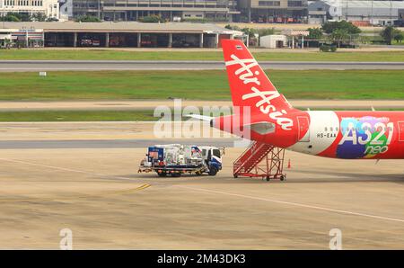 Camion-citerne de service terrestre ravitaillant un avion dans la baie d'aéronef - aéroport Don-Mueang, Thaïlande. Banque D'Images