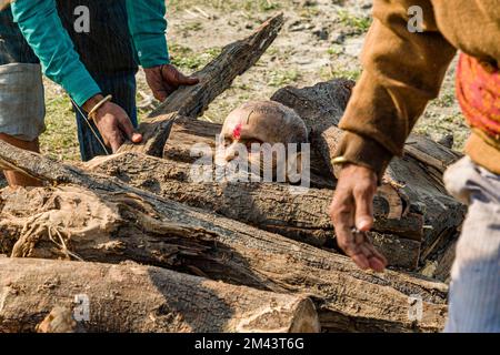 Mettre un corps de mort sur le bois de chauffage sur les rives de la rivière Yamuna dans le cadre d'une cérémonie de crémation Banque D'Images