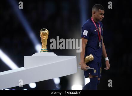 Vainqueur du Golden Boot, Kylian Mbappe, en France, est battu lorsqu'il passe devant le Trophée de la coupe du monde de la FIFA, après avoir subi une défaite en Argentine lors de la finale de la coupe du monde de la FIFA au stade Lusail, au Qatar. Date de la photo: Dimanche 18 décembre 2022. Banque D'Images