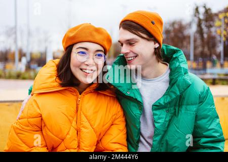 Jeune couple multiracial d'amoureux datant de l'extérieur en hiver, portant des vestes d'hiver et s'amusant - multiethnique de la génération du millénaire se liant dans une zone urbaine, Banque D'Images