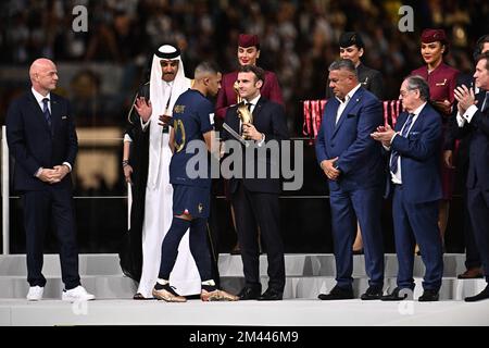 Doha, Qatar sur 18 décembre 2022. L'avant de la France (10) Kylian Mbappe reçoit le prix du bal d'or du meilleur joueur du président français Emmanuel Macron, à côté de l'émir Sheikh Tamim bin Hamad al-Thani (L) du Qatar, lors de la cérémonie de remise des trophées à la fin du match de football final de la coupe du monde du Qatar 2022 entre l'Argentine et la France à Lusail Stade de Lusail, au nord de Doha sur 18 décembre 2022. Photo de David Niviere/ABACAPRESS.COM Banque D'Images