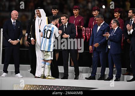 Doha, Qatar sur 18 décembre 2022. L'avant-projet argentin (10) Lionel Messi se met entre les mains du président français Emmanuel Macron après avoir reçu le Golden ball Award pour le meilleur joueur de l'émir Sheikh Tamim bin Hamad al-Thani (L) du Qatar lors de la cérémonie des trophées à la fin du match de football final de la coupe du monde du Qatar 2022 entre l'Argentine et La France au stade Lusail à Lusail, au nord de Doha, au Qatar, sur 18 décembre 2022. Photo de David Niviere/ABACAPRESS.COM Banque D'Images