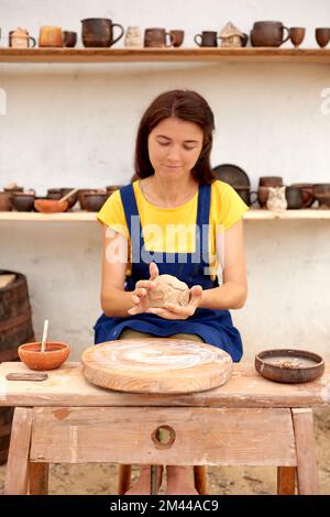 Potter avec pot d'argile humide dans les mains. les mains de l'artisan de la poterie sculptent dans l'argile Banque D'Images