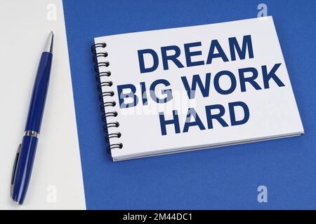 Concept commercial et financier. Sur une surface bleu-blanc se trouve un stylo et un carnet avec l'inscription - Dream Big Work Hard Banque D'Images