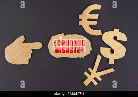 Concept d'économie et de finance. Sur une surface noire, figure d'une main, symboles d'argent et carton déchiré avec l'inscription - catastrophe économique Banque D'Images
