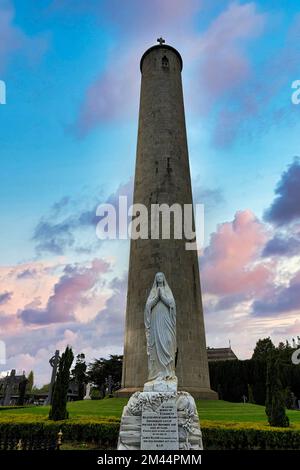 Statue de la Vierge Marie en face de la grande tour ronde, tour OConnell, ciel nocturne, cimetière Glasnevin, cimetière Prospect, Glasnevin, Dublin, Irlande Banque D'Images