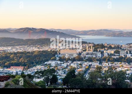 Vue imprenable sur un quartier résidentiel de San Francisco au coucher du soleil en automne. Le Golden Gate Bridge et la baie sont visibles en arrière-plan. Banque D'Images