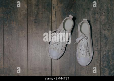 Sneakers blanches pour enfant avec effet pailleté. Sur un arrière-plan texturé Banque D'Images