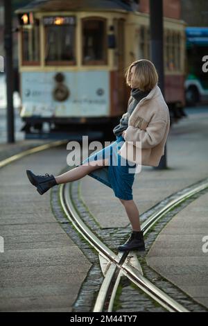 Une femme debout à côté d'un tramway rétro. Banque D'Images