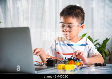 Petit enfant essayant d'assembler la roue de construction au jouet de voiture Banque D'Images