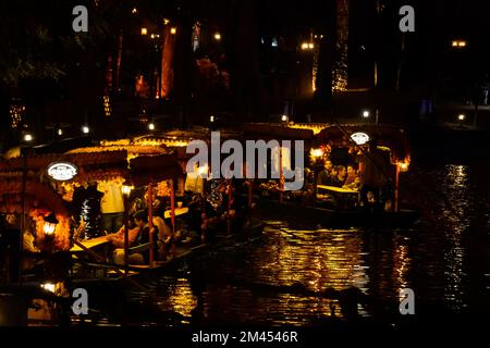 les gens nageant dans des trajineras et des lanchitas, la nuit sur l'eau Banque D'Images