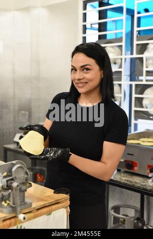 Femme mexicaine montrant des tacos pendant la cuisine Banque D'Images