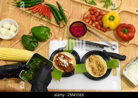 Oignon vert à la main pour préparer des Tacos dans un restaurant mexicain Banque D'Images