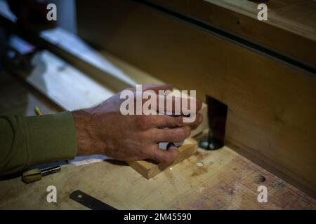 Traitement du bois. Main de menuisier. Détails du travail en atelier de menuiserie. Mains tenir blanc en bois. Banque D'Images