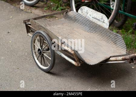 Chariot sur roues. Remorque à vélo. Transport de marchandises. Pièces de transport mécanique. Banque D'Images