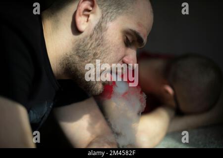 Guy fume. Homme avec cigarette. L'homme est fatigué. Dirigez-vous au soleil. Après la fête. Banque D'Images