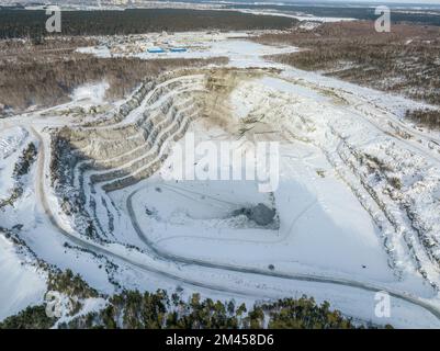 Vue aérienne de la carrière de pierre concassée en hiver avec de la neige. Exploitation de la pierre concassée en hiver. Banque D'Images