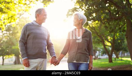 Je savais que je voulais grandir avec vous. un couple affectueux de personnes âgées se promenant ensemble tout en tenant les mains au parc. Banque D'Images