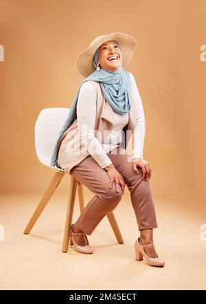 Femme musulmane, foulard de mode ou chaise en studio à Dubaï, chapeaux élégants et tendance ou vêtements arabes frais. Sourire heureux, rire ou mûrir Banque D'Images