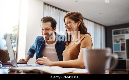 Je suppose que ces chiffres étaient tous les deux satisfaits. un jeune couple qui réalise une planification financière ensemble sur un ordinateur portable à la maison. Banque D'Images