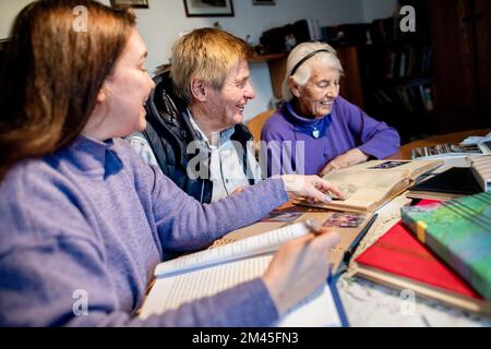 Bassum, Allemagne. 09th décembre 2022. L'auteur Susanne Hinrichs (l) regarde les anciennes photos des albums photos du couple avec Wolf-Rüdiger et Ilse Baerwinkel. L'auteur Susanne Hinrichs écrit des biographies pour le compte de personnes qui ne sont pas célèbres mais qui veulent encore laisser une histoire de vie professionnelle écrite pour leurs descendants. (À dpa 'Life Stories: Biographer écrit au nom de tout le monde') Credit: Hauke-Christian Dittrich/dpa/Alamy Live News Banque D'Images