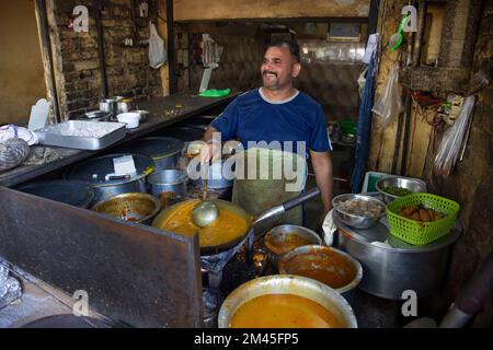 Un cuisinier et un propriétaire d'un restaurant de bord de route local ou un dhaba, cuisinant de la nourriture pendant l'heure du déjeuner Banque D'Images