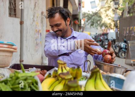 Un vendeur de légumes vend des légumes à son stand de bord de route Banque D'Images