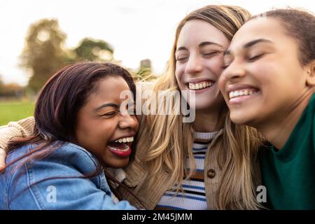 Authentique multi-ethnique meilleures femmes amis s'embrassant les uns les autres à l'extérieur Banque D'Images