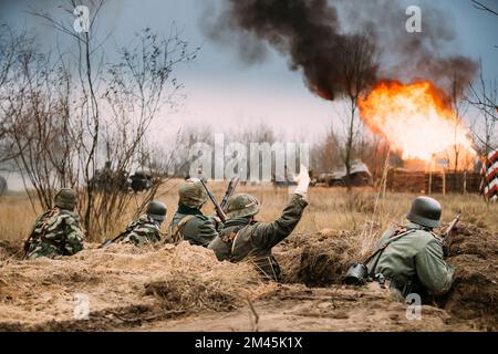 Position défensive. Les réacteurs ont armé des fusils et se sont habillés comme soldats allemands de l'infanterie Wehrmacht de la Seconde Guerre mondiale combattant de manière défésive dans le Trench. Bâtiment Banque D'Images