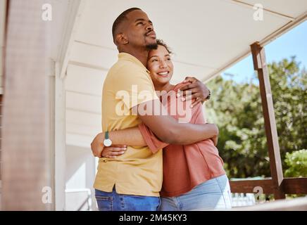 Couple noir, collage et amour hug dans la maison ou patio à la maison comme nouveaux propriétaires immobiliers, succès d'investissement hypothécaire ou acheteurs immobiliers. Sourire, heureux et Banque D'Images