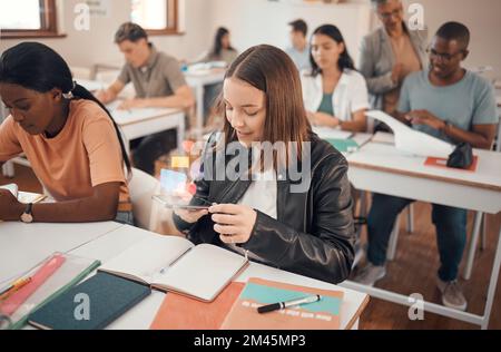 L'éducation, le téléphone et l'étudiant texting dans une salle de classe, les médias sociaux et l'addiction d'Internet avec hologramme. École, fille et smartphone avec double Banque D'Images