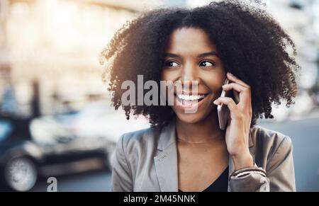 Votre offre semble trop intéressante à transmettre. une jeune femme d'affaires qui parle sur un téléphone portable dans la ville. Banque D'Images