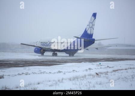 Odessa, Ukraine - VERS 2018 : avion de ligne de la compagnie de Belavia sur piste en blizzard. Avion en train de rouler sur la piste d'atterrissage pendant une forte neige. Passager Banque D'Images