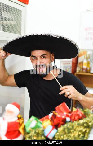 Homme mexicain dans un sombrero tenant la moustache sur un bâton et sourit dans l'appareil photo Banque D'Images