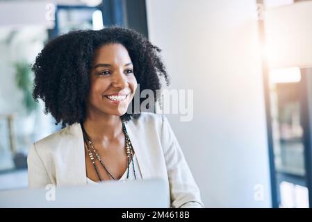 De nouvelles possibilités sont à l'horizon. une jeune femme d'affaires souriant et dans de bons esprits à son bureau. Banque D'Images