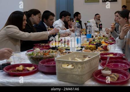 JÉRUSALEM, ISRAËL - DÉCEMBRE 18 : le rabbin Yitzchak Goldstein, chef de la Diaspora Yeshiva mange avec son dîner festif en famille la première nuit de la fête juive de Hanukkah, parfois appelée le festival des lumières, sur 18 décembre 2022 à Jérusalem, Israël. Les Juifs du monde entier célèbrent aujourd'hui le premier jour de Hanukkah, le festival juif de huit jours. Hanoukkah, ou Chanukah, commémore la victoire juive en 165 avant J.-C. sur l'oppression syro-grecque menée par le roi Antiochus IV Crédit : Eddie Gerald/Alay Live News Banque D'Images