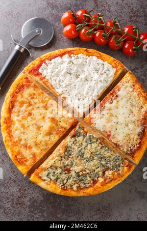 Pizza chaude en tranches quatre fromages gros plan sur une planche de bois sur la table. Vue verticale du dessus Banque D'Images